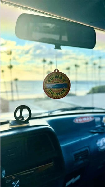 Fu Wax Air Freshener on rearview mirror at sunset